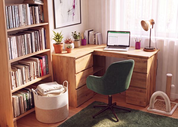 Hjemmekontor med hj&oslash;rneskrivebord i tre, ergonomisk gr&oslash;nn kontorstol, b&aelig;rbar PC, bokhylle, skrivebordslampe og gr&oslash;nne planter, som skaper en komfortabel og produktiv arbeidsplass hjemme.