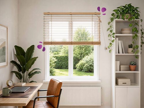 Et hjemmekontorhj&oslash;rne med en persienne i tre montert over et stort vindu, som mykt slipper inn naturlig lys og vender ut mot en gr&oslash;nn hage utenfor. Et skrivebord i tre og en skinnstol st&aring;r under, med en h&oslash;y plante og hvite &aring;pne hyller med sm&aring; kaktuser p&aring; hver side, noe som skaper en rolig og luftig arbeidsplass.