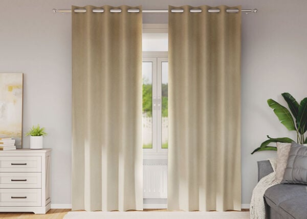 Beige gardiner filtrerer sollyset i et koselig rom.