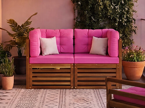 Nytt modul&aelig;rt balkongsofa-sett med tydelige rosa puter og solid trestel, stilet p&aring; en bybalkong med planter og glassrekkverk, NEW-merke vist