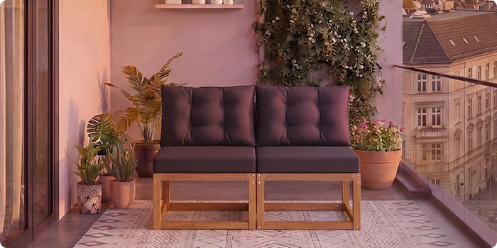  Toseter modulær tresofa med mørkegrå puter på en balkong omgitt av potteplanter og byutsikt i bakgrunnen