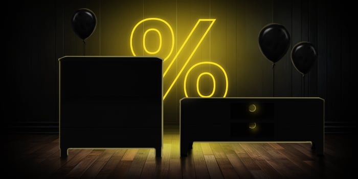  Svart kommode og TV-konsoll med svarte ballonger foran et lyst gult prosenttegn på et mørkt tregulv.