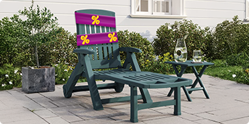 Grønn solseng i plast og matchende bord på terrassen, med solsengen pakket inn i et lilla reklamebånd med gule rabattikoner. Klikk for å se produktene i tilbudet.